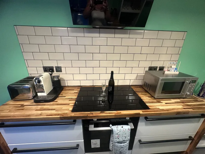 Kitchen worktop with hob, oven, microwave, coffee machine and toaster.